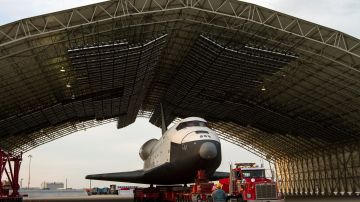 En esta foto de folleto proporcionado por la NASA, el transbordador espacial Enterprise, montado en un vehículo de transporte, está respaldado en una suspensión temporal.