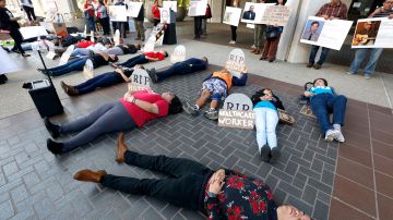 Activistas se tumbaron sobre el piso representando a los miles de trabajadores que pierden la vida en sus lugares de trabajo. (Aurelia Ventura/La Opinion)