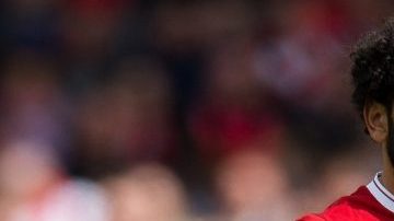 El delantero egipcio del Liverpool Mohamed Salah lucha con Lionel Messi por el Botín de Oro. (EFE/EPA/PETER POWELL)