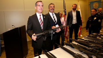 El alcalde Eric Garcetti sostiene una de las armas entregadas. (Aurelia Ventura/La Opinion)