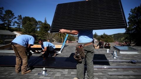 Trabajadores instalan paneles solares en el techo de una casa en San Rafael, California.