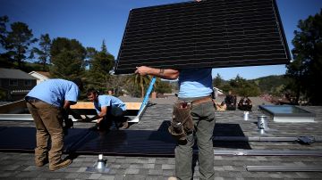 Trabajadores instalan paneles solares en el techo de una casa en San Rafael, California.