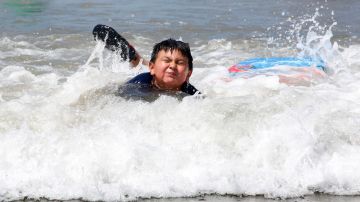 Un niño se divierte jugando en el mar, en el condado de Los Ángeles. (Aurelia Ventura/La Opinion)