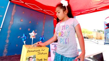 Una niña deposito dinero en una caja de recaudación de fondos para ayudar a Joshua Casillas. (Aurelia Ventura/La Opinion)