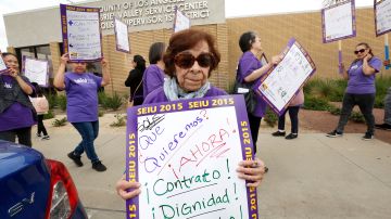 La trabajadora María Salim sostiene un letrero que reza: ‘Queremos ahora contrato, dignidad y respeto’. / Foto: Aurelia Ventura.