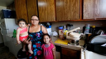 Jackeline López, junto a sus dos pequeñas hijas, dice luchar para evitar ser desalojada. / Foto: Aurelia Ventura.