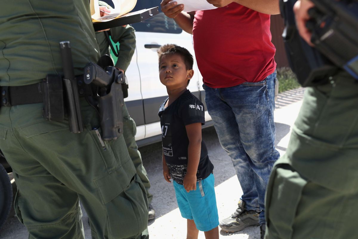 Un niño y su padre, originarios de Honduras, piden asilo a agentes fronterizos. 