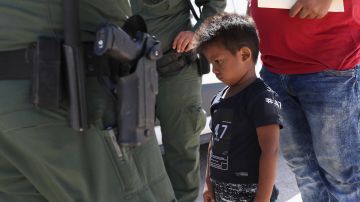 Un niño y un padre son detenidos por agentes de la Patrulla Fronteriza cerca de la frontera.