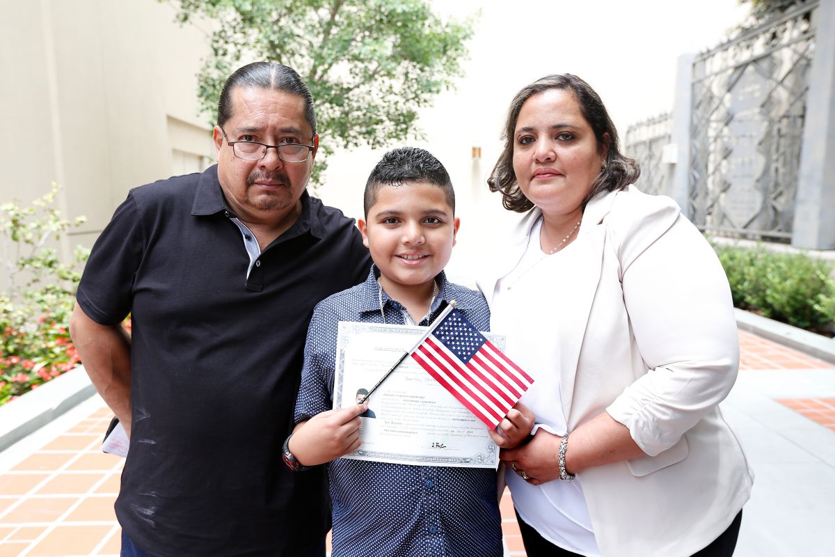 Franzel Saldana, de 10 años, junto a sus padres Javier y Hazel Saldana durante la ceremonia de ciudadanía en la Biblioteca de Los Ángeles. (Aurelia Ventura/ La Opinion)