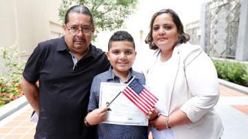 Franzel Saldana, de 10 años, junto a sus padres Javier y Hazel Saldana durante la ceremonia de ciudadanía en la Biblioteca de Los Ángeles. (Aurelia Ventura/ La Opinion)