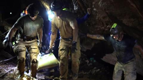 Un menor es trasladado en camilla hacia el interior de la cueva en Tailandia.