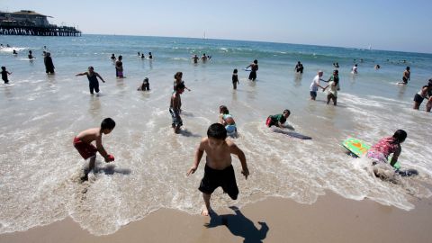 Familias se deleitan de las olas en Santa Mónica.