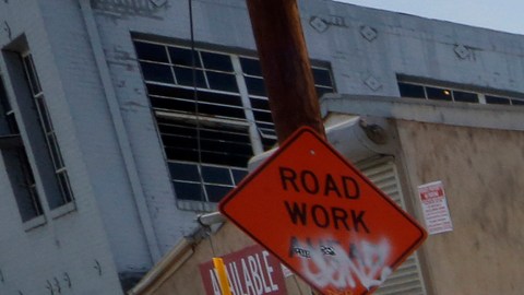 Peatones caminan por una calle llena de baches en Los Angeles.  (Aurelia Ventura/La Opinion)