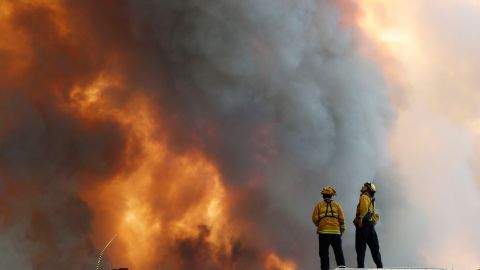 Bomberos observan una colina en llamas en Lakeport, California.