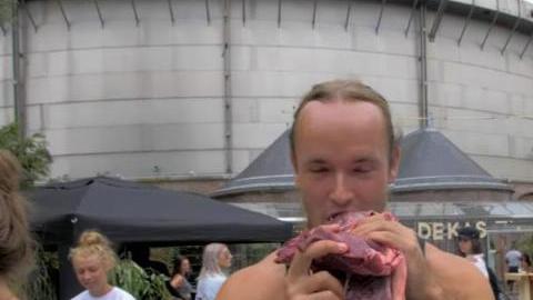 Hombre come carne en festival vegano