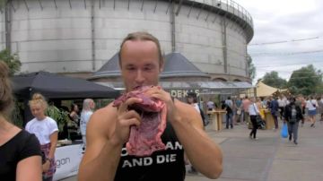 Hombre come carne en festival vegano