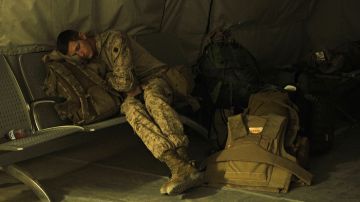 Un soldado descansa mientras aguarda por su transporte.