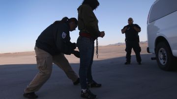 Agente de ICE revisa a una mujer originaria de Honduras, antes de deportarla a San Pedro Sula.