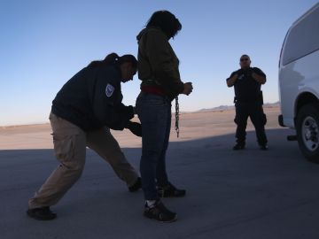 Agente de ICE revisa a una mujer originaria de Honduras, antes de deportarla a San Pedro Sula.