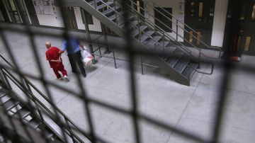 Un guardia traslada a un inmigrante detenido en una cárcel privada de California.