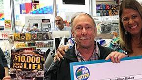 Michael Marks muestra su premio y el juego de raspadito ganador.