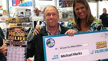 Michael Marks muestra su premio y el juego de raspadito ganador.