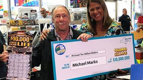 Michael Marks muestra su premio y el juego de raspadito ganador.