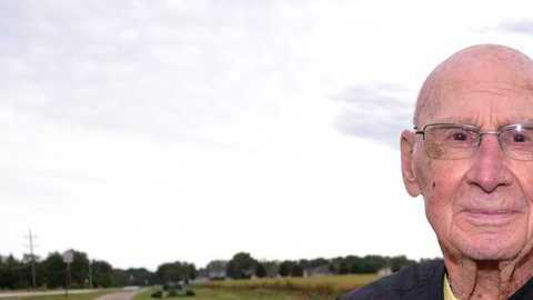 Bob Williams de Long Grove, Iowa, sentado en el banco dedicada a su difunta esposa.