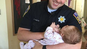El oficial de policía con el bebé que acaba de adoptar.
