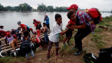 Un grupo de migrantes hondureños cruza ilegalmente el río Suchiate en balsas para llegar a México desde Tecún Umán.