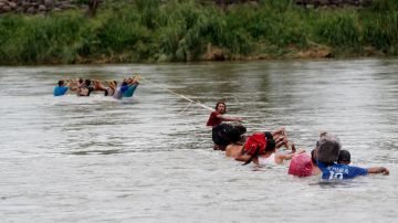 Migrantes hondureños cruzan a pie el río Suchiate, que separa a Guatemala de México.