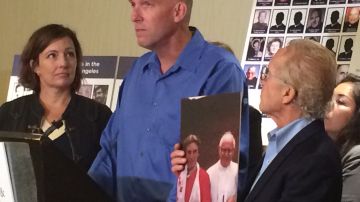 Tom Emens junto al abogado Jeff Anderson, quien sostiene una foto del cura que Emens dice abusó de él. ()