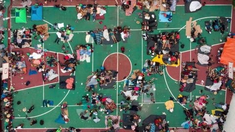 Migrantes en camino a EEUU descansan en una cancha en México.