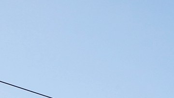 El agente J. Barrios de la Patrulla de Carreteras de California (CHP) regala una banda reflectiva a Moises Fernández en la esquina de la Avenida Vermont y el Bulevar (Aurelia Ventura/La Opinion)