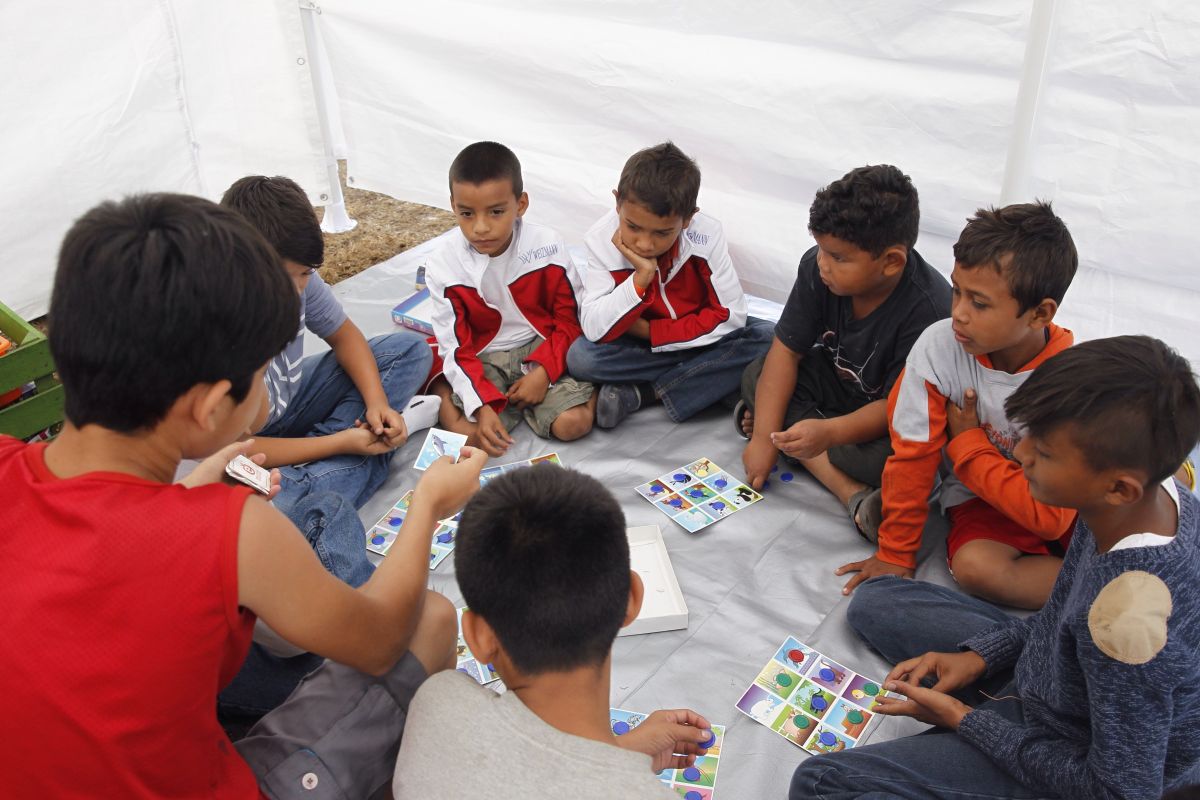 Niños de la caravana de migrantes juegan en refugio. 