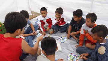 Niños de la caravana de migrantes juegan en refugio.