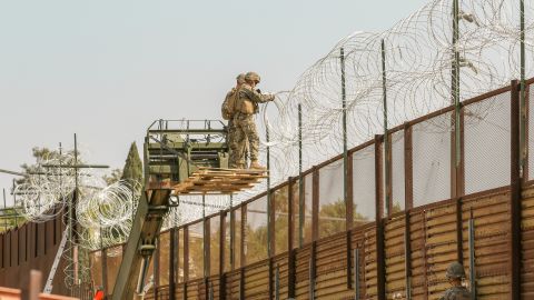 Infantes de marina y soldados fortifican la cerca fronteriza en el sur de California.