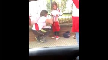 Una aficionada del River Plate coloca luces de bengala en el cuerpo de una niña