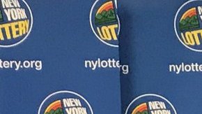 Los tres ganadores con sus cheques ceremoniales de lotería.