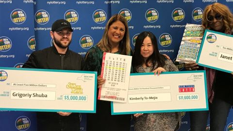 Los tres ganadores con sus cheques ceremoniales de lotería.