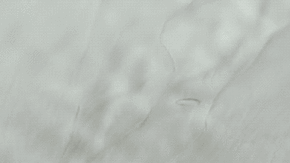 Dos vistas de la región del cráter Hiawatha: una cubierta por hielo, la otra con la roca debajo.