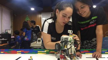 Martha, de 17 años y Erika, de 12 años, programan un robot.
