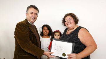 12/07/18 / LOS ANGELES/ Mexican consul Carlos Garcia de Alba poses with graduate Karina Espinoza and her children, Karina, 10, and Maritza, 3. Karina was among 74 who received a certificate for completing a five week course on child care course. (Aurelia Ventura/La Opinion)