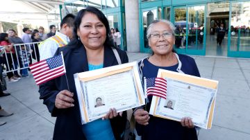 Alberta Velázquez y Luz María Ramírez sonríen contentas con sus certificados tras convertirse en ciudadanas estadounidenses en la última ceremonia de naturalización en Los Ángeles este año. (Aurelia Ventura/La Opinion)