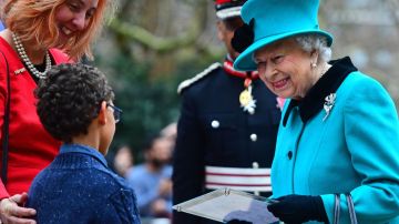 La reina Isabel II de Inglaterra y el niño protagonista del vídeo viral.