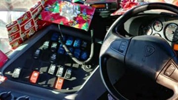 Conductor de autobús regala juguetes a los niños.