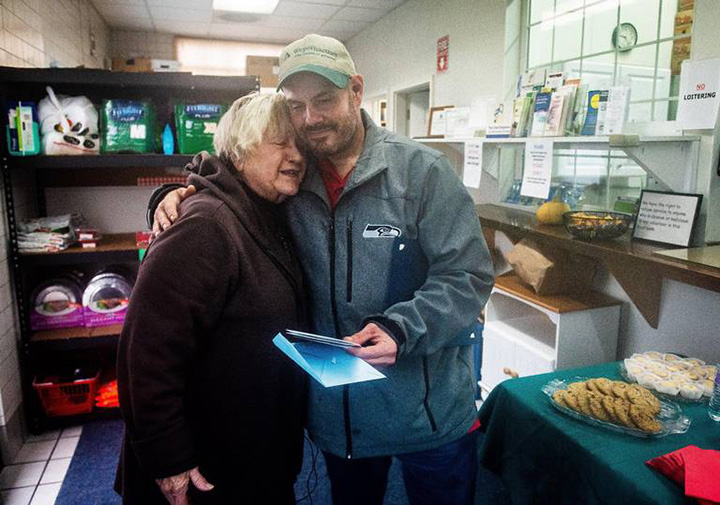 Kevin Booth abraza Anita Miller, directora de Sumner Food Bank