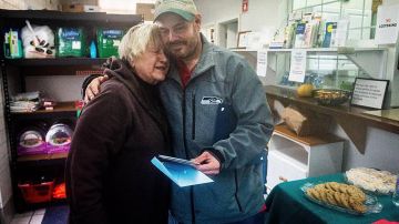 Kevin Booth abraza Anita Miller, directora de Sumner Food Bank