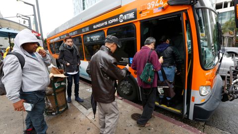 Pasajeros toman el autobús en la esquina del Bulevar Wilshire y la Avenida Vermont en Los Ángeles. (Aurelia Ventura/La Opinion)
