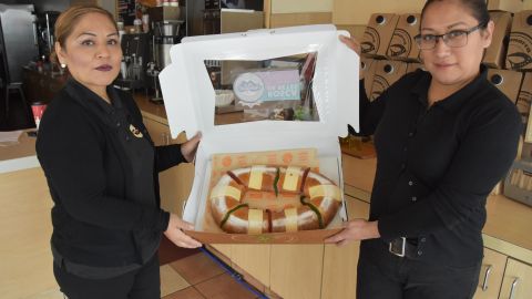 Erika Ronson (i) y Shugey Rivera posan con una rosca de reyes de La Monarca.